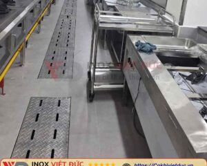 Hình ảnh minh họa thoát sàn inox sử dụng trong khu vực nhà bếp, bếp nhà hàng và bếp ăn công nghiệp. Hệ thống có thể kết hợp máng thu nước, nắp vỉ tháo rời, bộ phận lọc rác và đầu nối ống xả tùy theo cấu hình. Inox Việt Đức nhận gia công thoát sàn inox 304 theo kích thước và bản vẽ, phù hợp với điều kiện lắp đặt thực tế tại TP.HCM.